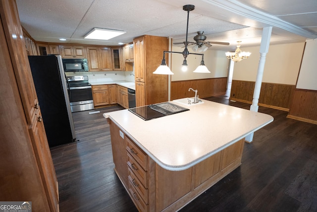 kitchen with light countertops, wainscoting, a large island, and black appliances