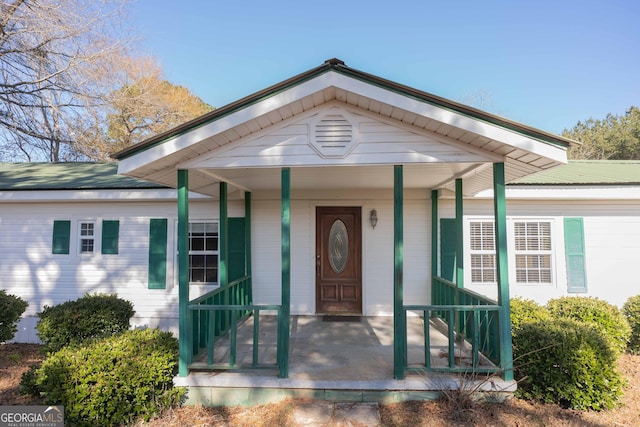 view of exterior entry with a porch