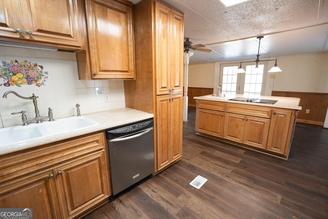 kitchen with a sink, light countertops, black appliances, and pendant lighting