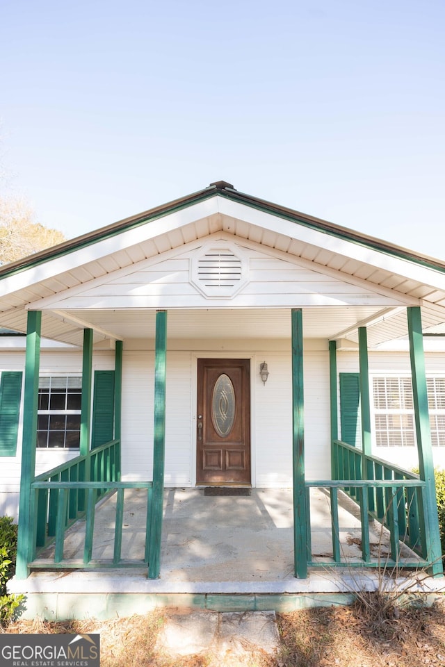 view of exterior entry featuring covered porch