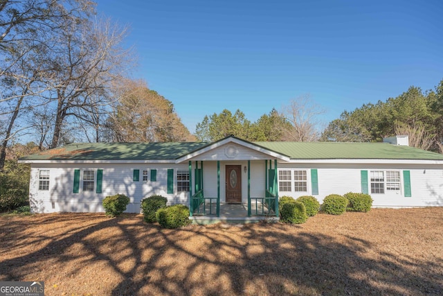 ranch-style house with metal roof and a front lawn