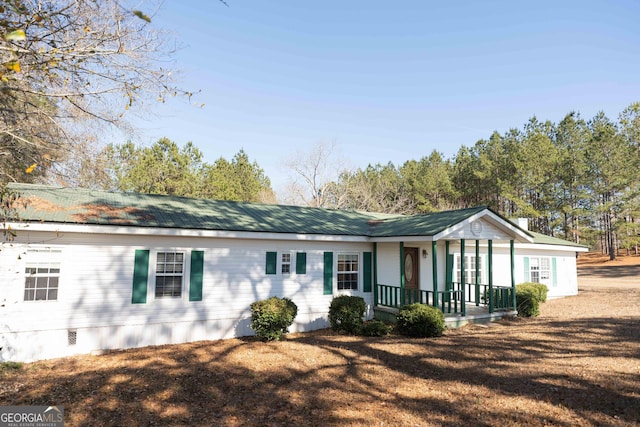 ranch-style house with metal roof, crawl space, a front lawn, and covered porch