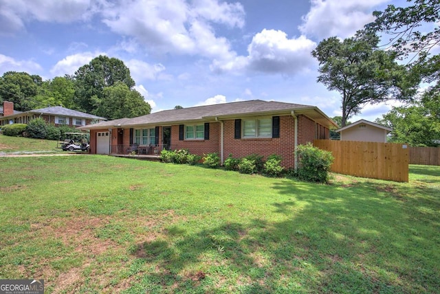 ranch-style home with brick siding, an attached garage, fence, and a front lawn