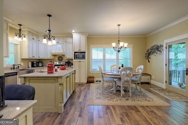 153 Falls Creek Dr, Hiawassee, GA 30546 - kitchen with a chandelier, stainless steel appliances, hardwood / wood-style floors, ornamental molding, and custom exhaust hood