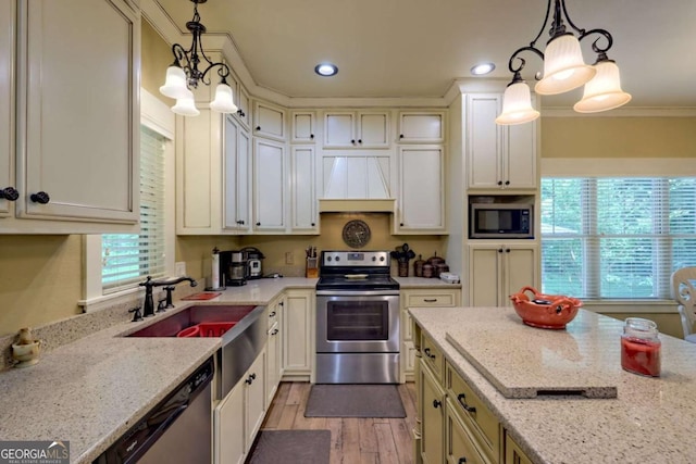 153 Falls Creek Dr, Hiawassee, GA 30546 - kitchen with appliances with stainless steel finishes, custom exhaust hood, light wood-style flooring, light stone countertops, and crown molding
