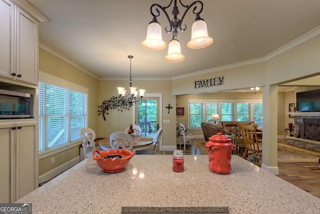 153 Falls Creek Dr, Hiawassee, GA 30546 - kitchen featuring a chandelier, stainless steel microwave, ornamental molding, open floor plan, and light stone counters