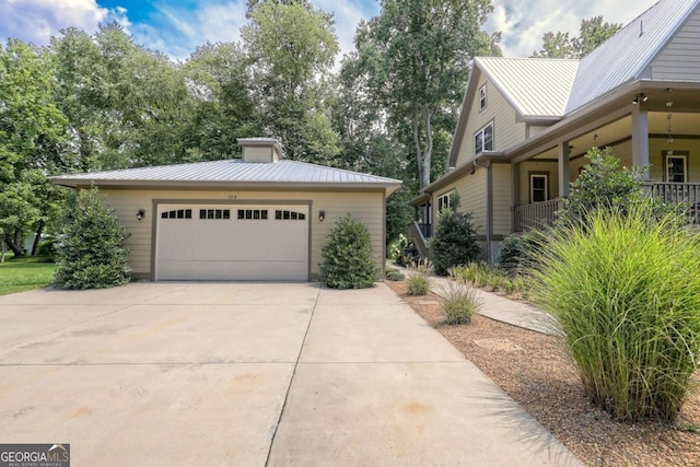153 Falls Creek Dr, Hiawassee, GA 30546 - view of side of property featuring a metal roof, an attached garage, driveway, a chimney, and an outdoor structure