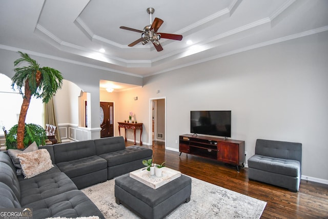 living area featuring crown molding, baseboards, a raised ceiling, and dark wood-type flooring