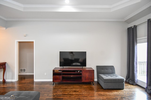 living area with baseboards, visible vents, dark wood-style flooring, a tray ceiling, and crown molding