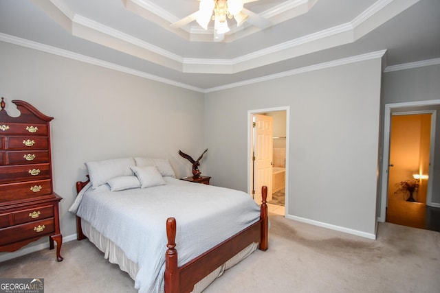 bedroom featuring a tray ceiling, ornamental molding, light carpet, connected bathroom, and baseboards