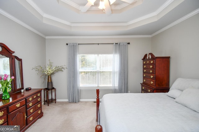 bedroom featuring a tray ceiling, crown molding, a ceiling fan, light carpet, and baseboards