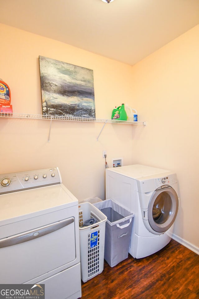 laundry area featuring independent washer and dryer, laundry area, dark wood finished floors, and baseboards