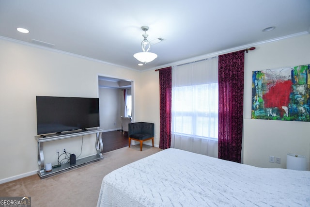 carpeted bedroom with visible vents, baseboards, and crown molding