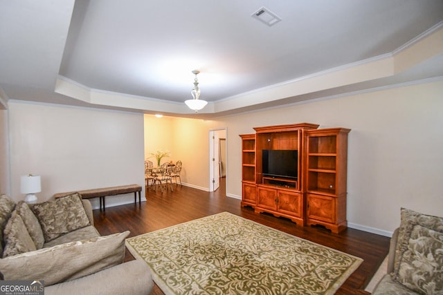 living area featuring a tray ceiling, dark wood-style flooring, and visible vents