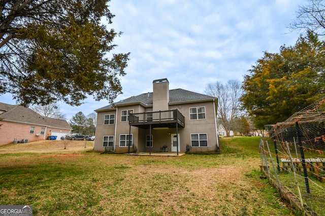 back of property with a deck, a lawn, a chimney, and stucco siding