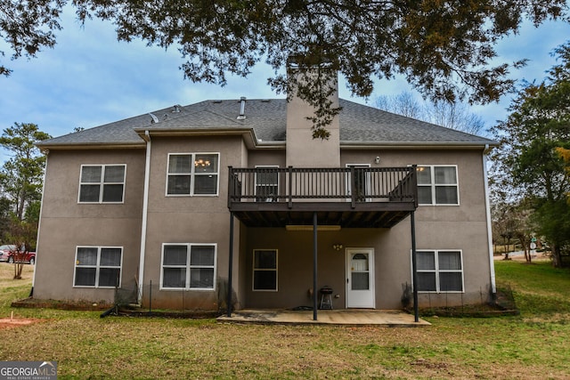 back of property featuring a shingled roof, stucco siding, a lawn, and a patio