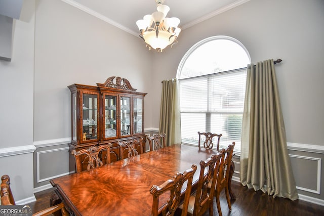 dining room with wainscoting, ornamental molding, dark wood-style flooring, an inviting chandelier, and a decorative wall