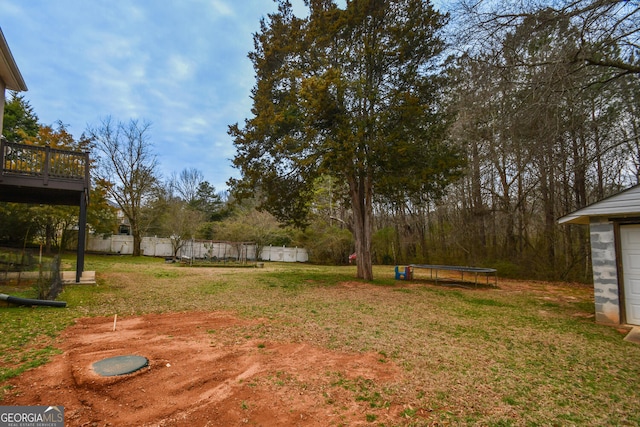 view of yard featuring a trampoline and fence