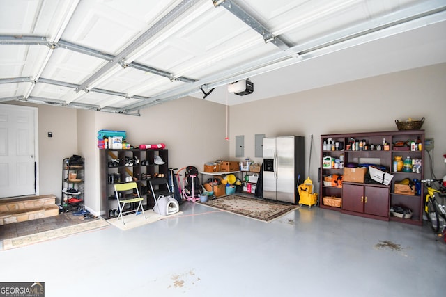 garage featuring stainless steel fridge, electric panel, and a garage door opener