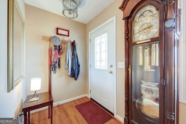 foyer featuring light wood-style flooring and baseboards