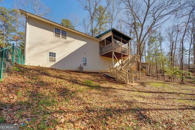 rear view of house with fence, a balcony, stairs, and cooling unit