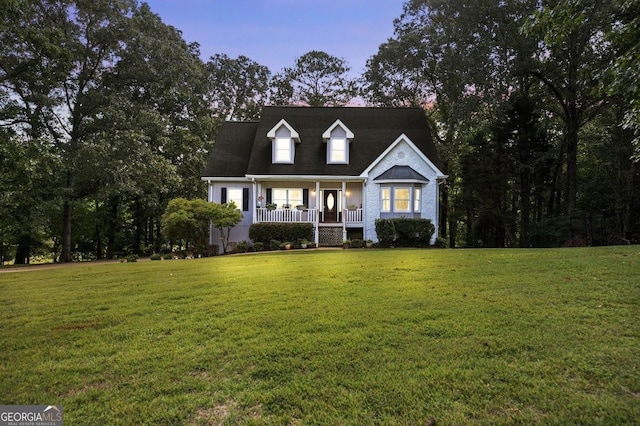 cape cod-style house with a porch and a front yard