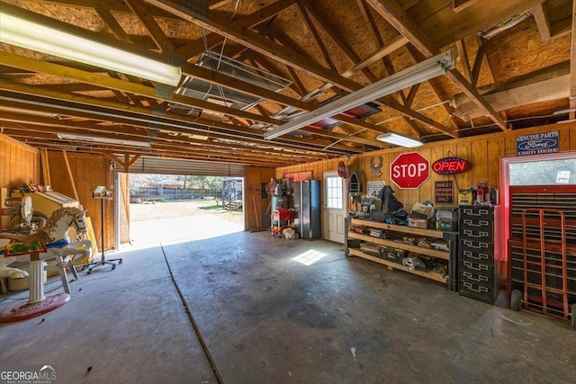 garage with freestanding refrigerator and a workshop area