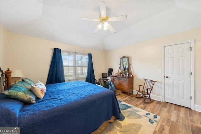 bedroom featuring vaulted ceiling, a ceiling fan, light wood-style flooring, and baseboards