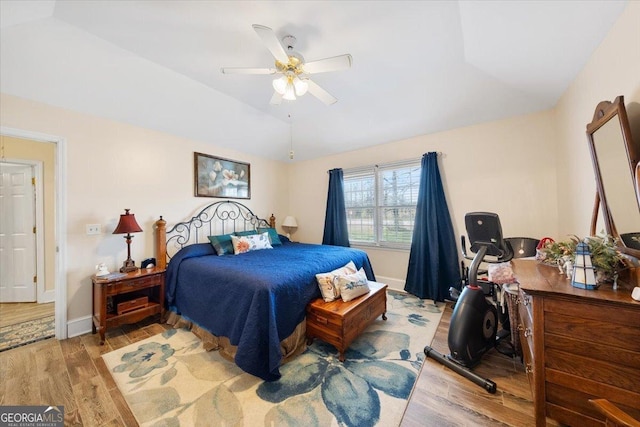 bedroom with baseboards, a ceiling fan, lofted ceiling, and light wood-style flooring