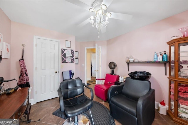 sitting room with baseboards, ceiling fan, and dark tile patterned flooring