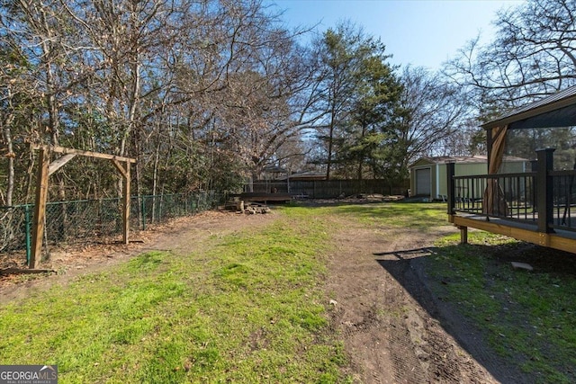 view of yard with a deck, an outbuilding, and a fenced backyard