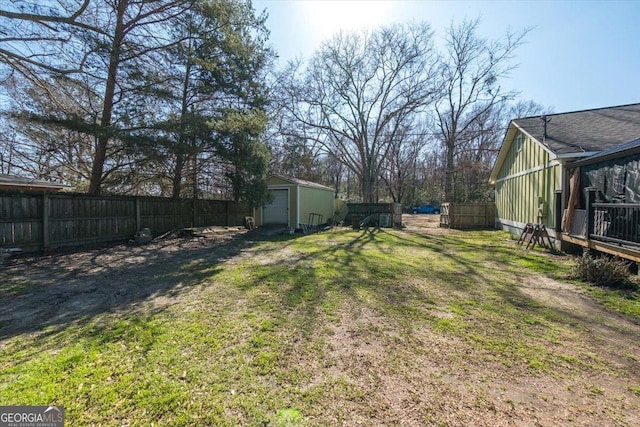 view of yard featuring a storage shed, an outdoor structure, and a fenced backyard