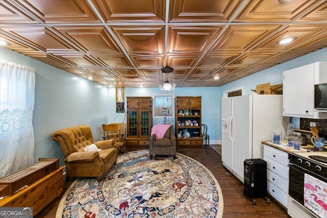 sitting room with dark wood-style flooring and an ornate ceiling