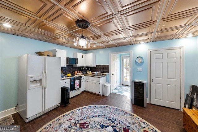 kitchen with white cabinetry, a sink, an ornate ceiling, dark wood-type flooring, and white appliances