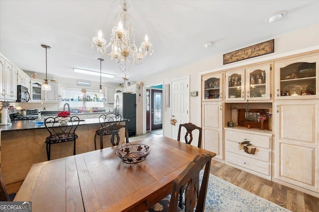 dining room with ceiling fan with notable chandelier and light wood finished floors