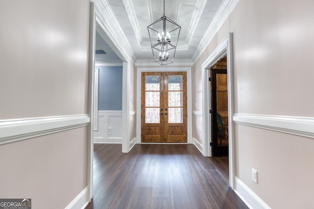 foyer entrance featuring dark wood finished floors, an inviting chandelier, crown molding, and french doors
