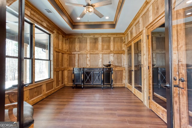interior space with wood walls, ornamental molding, visible vents, french doors, and dark wood-style flooring