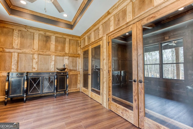 interior space featuring ceiling fan, a raised ceiling, and french doors