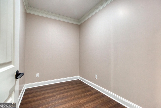unfurnished room featuring dark wood-style flooring, ornamental molding, and baseboards
