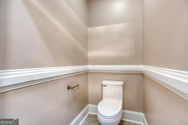 bathroom featuring toilet and baseboards