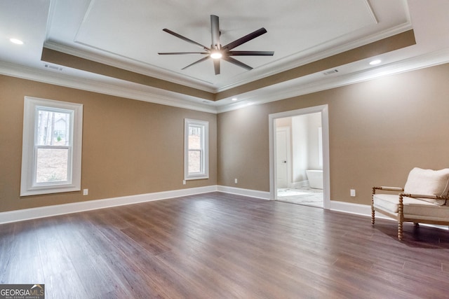unfurnished room featuring a healthy amount of sunlight, wood finished floors, and a tray ceiling