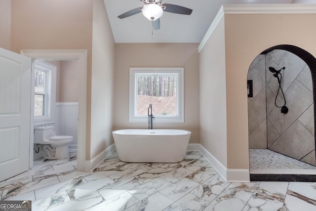 bathroom with plenty of natural light, marble finish floor, a freestanding tub, and toilet