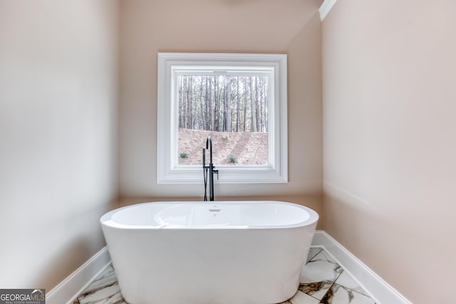 full bathroom with baseboards and a freestanding bath