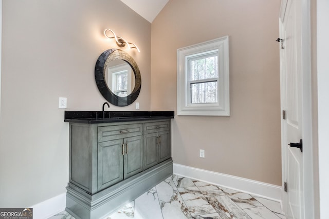bathroom featuring baseboards, vanity, lofted ceiling, and marble finish floor