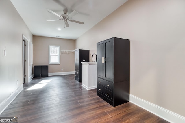 interior space with dark wood finished floors, baseboards, and a ceiling fan
