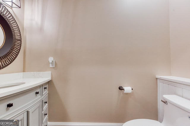 bathroom featuring vanity, toilet, and baseboards
