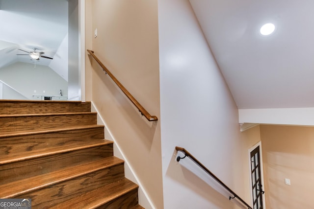 stairway with ceiling fan and lofted ceiling