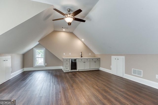 bonus room with baseboards, visible vents, dark wood-style flooring, and wine cooler