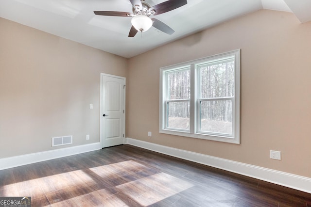 empty room featuring a ceiling fan, visible vents, baseboards, and dark wood-type flooring