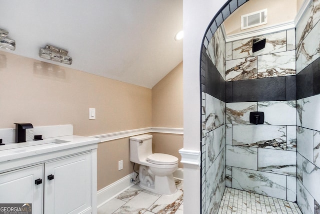 bathroom with a tile shower, vanity, marble finish floor, visible vents, and toilet